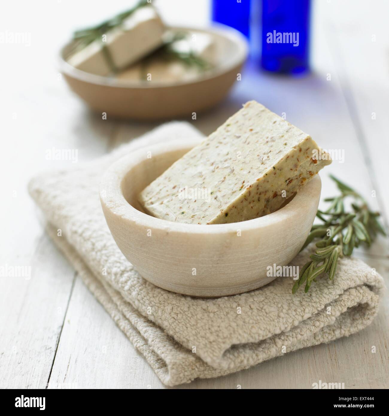 Il rosmarino sapone in ciotola, una salvietta ripiegata e rametto di rosmarino fresco, close-up Foto Stock