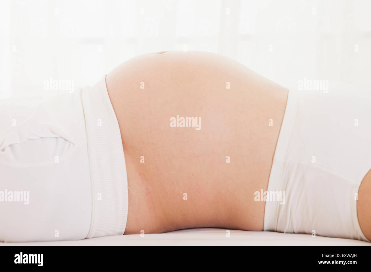 Donna incinta sdraiato sulla schiena, Foto Stock