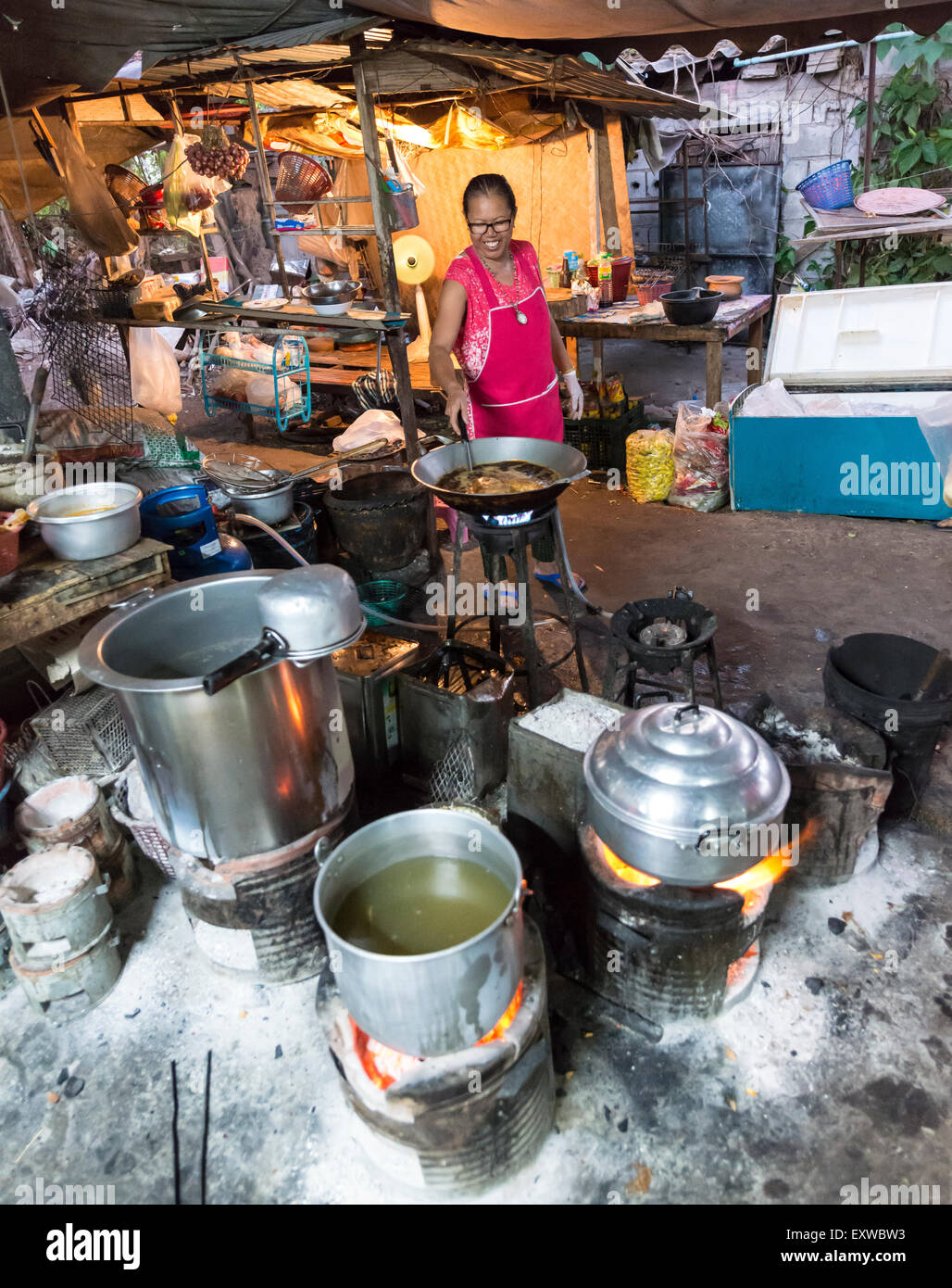 Donna thai prepara il cibo, pentole sopra un fuoco aperto, ristorante tradizionale, la Provincia di Kanchanaburi, Tailandia Centrale, Thailandia Foto Stock