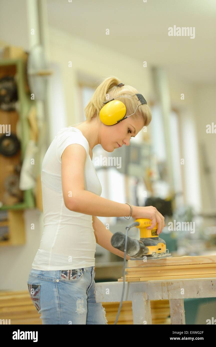 Giovane donna in un lavoro di carpenteria su un telaio della finestra Foto Stock