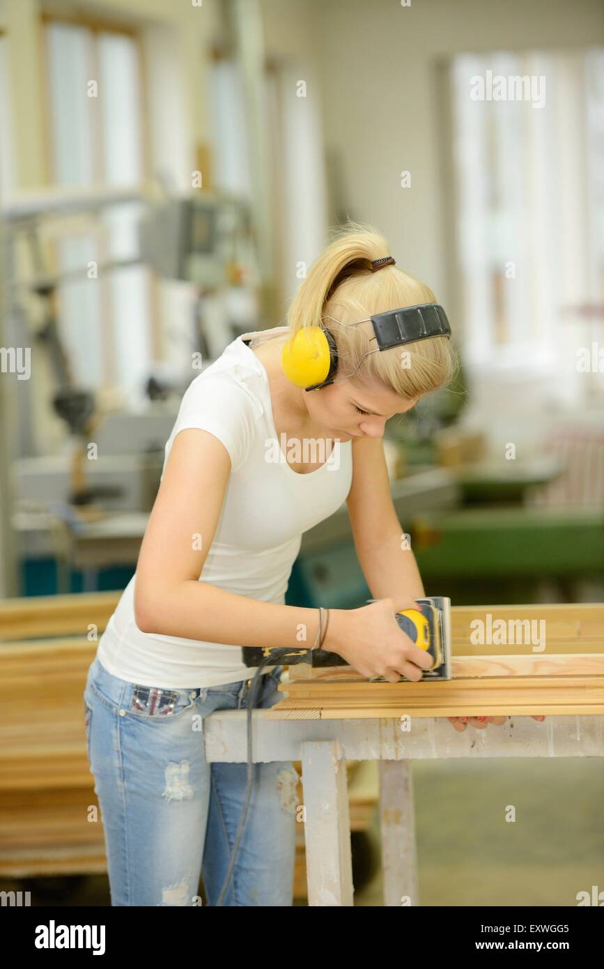 Giovane donna in un lavoro di carpenteria su un telaio della finestra Foto Stock