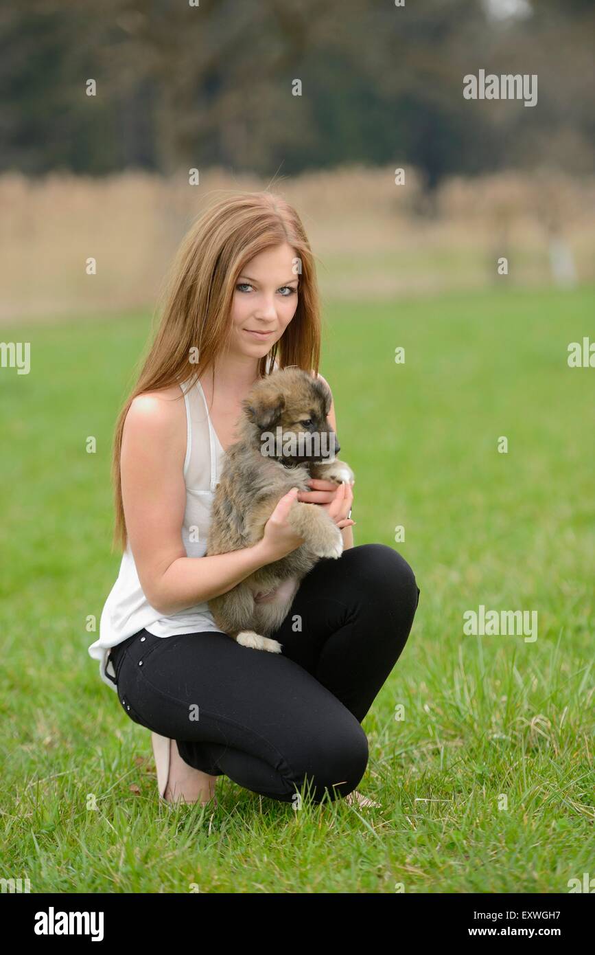 Giovane donna con un misto di razza cucciolo di cane in giardino Foto Stock