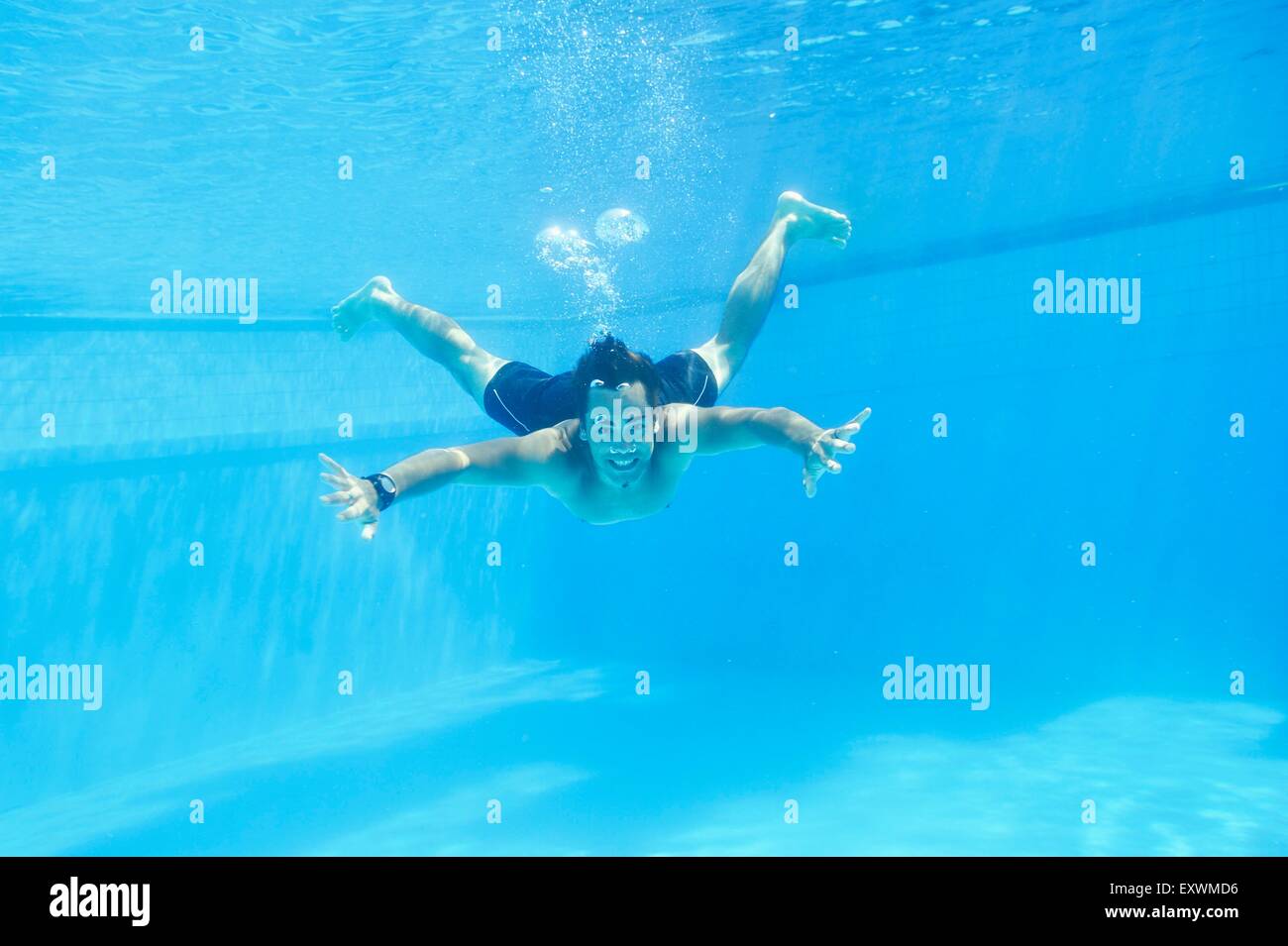 L'uomo nuotare sotto l'acqua in un open-air bath Foto Stock