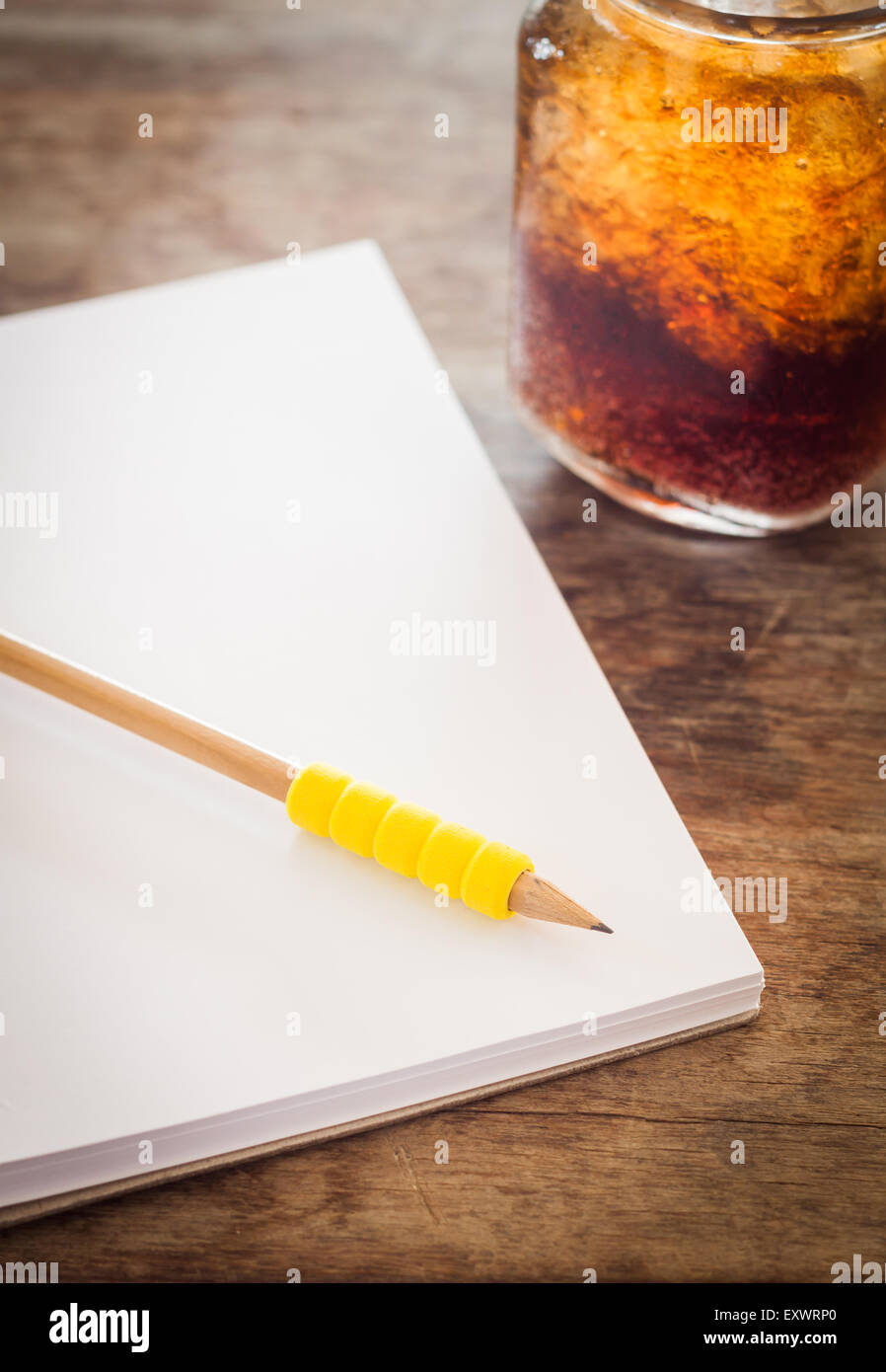 Matita sul fustellato aperto il notebook con bicchiere di coca cola ghiacciata, stock photo Foto Stock