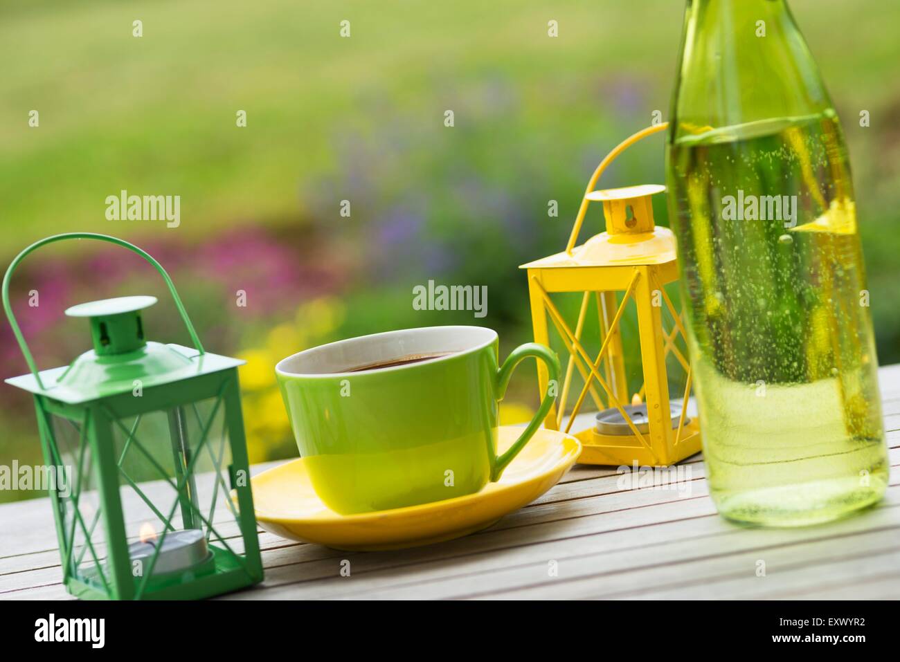 Tavolo da giardino con tazze di caffè e Lanterna portatile Foto Stock
