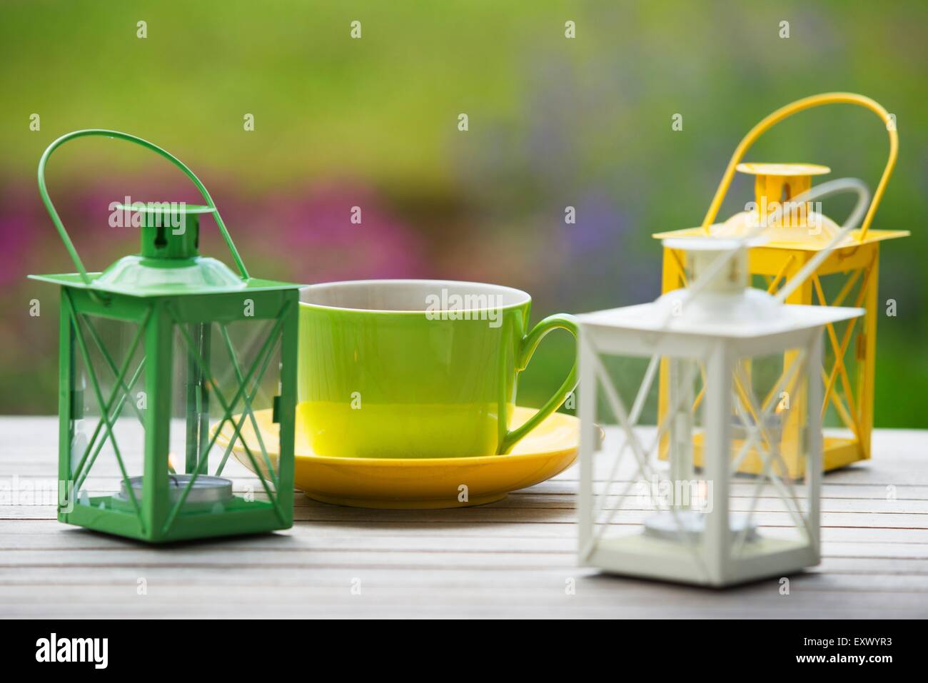 Tavolo da giardino con tazze di caffè e lanterna di tabella Foto Stock