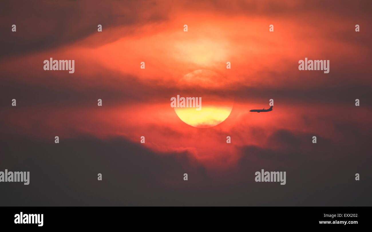 Silhouette di un aereo contro il sole di setting Foto Stock
