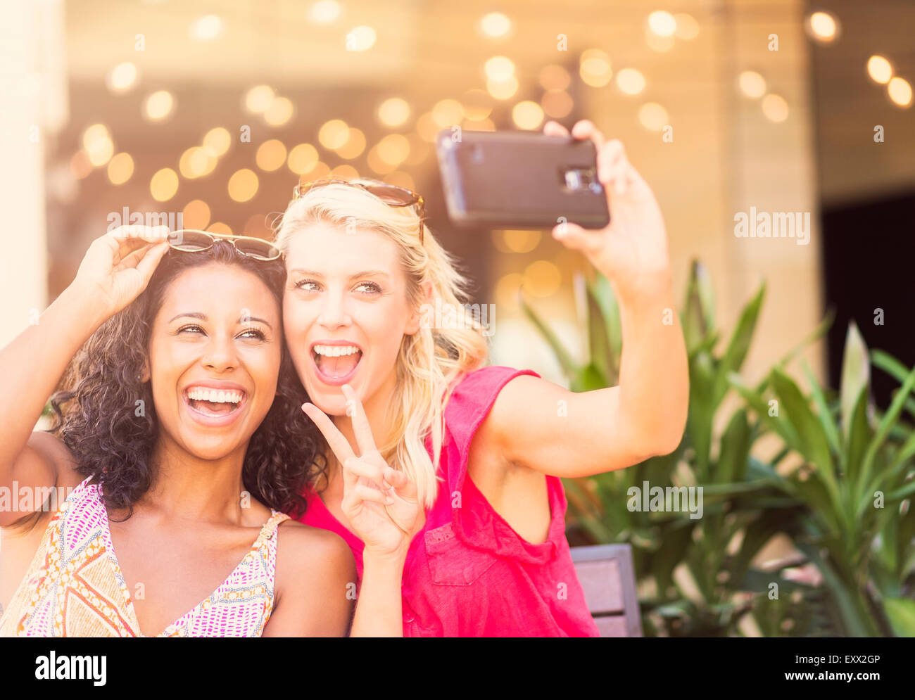 Amici di sesso femminile prendendo selfie con smart phone in cafe Foto Stock