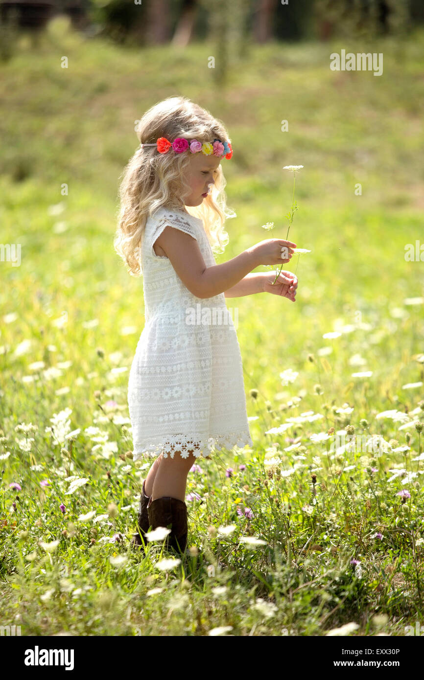 Ragazza carina (4-5) in abito bianco in piedi in Prato Foto Stock