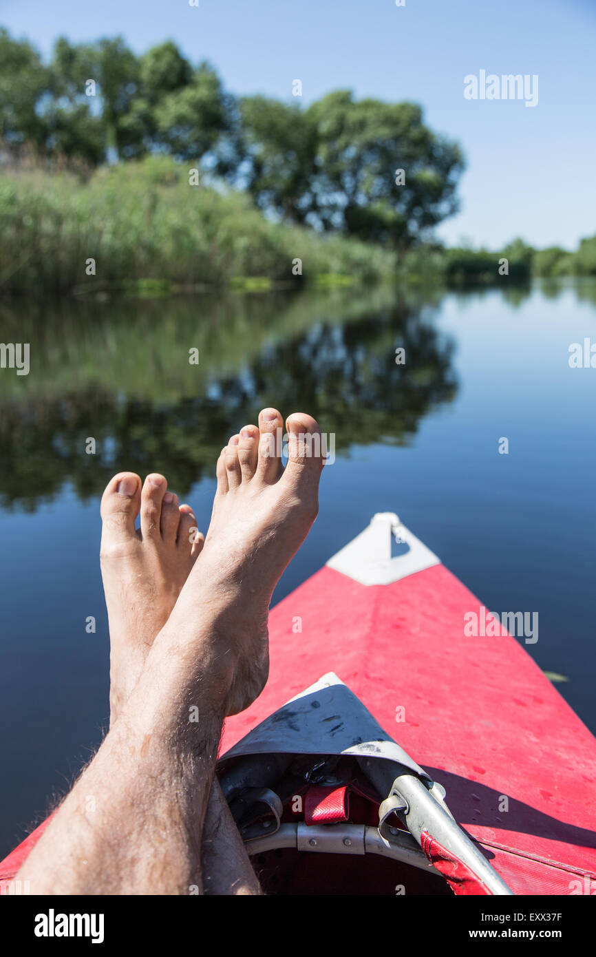 Uomo di gambe su canoe. Tempo di riposo. Foto Stock