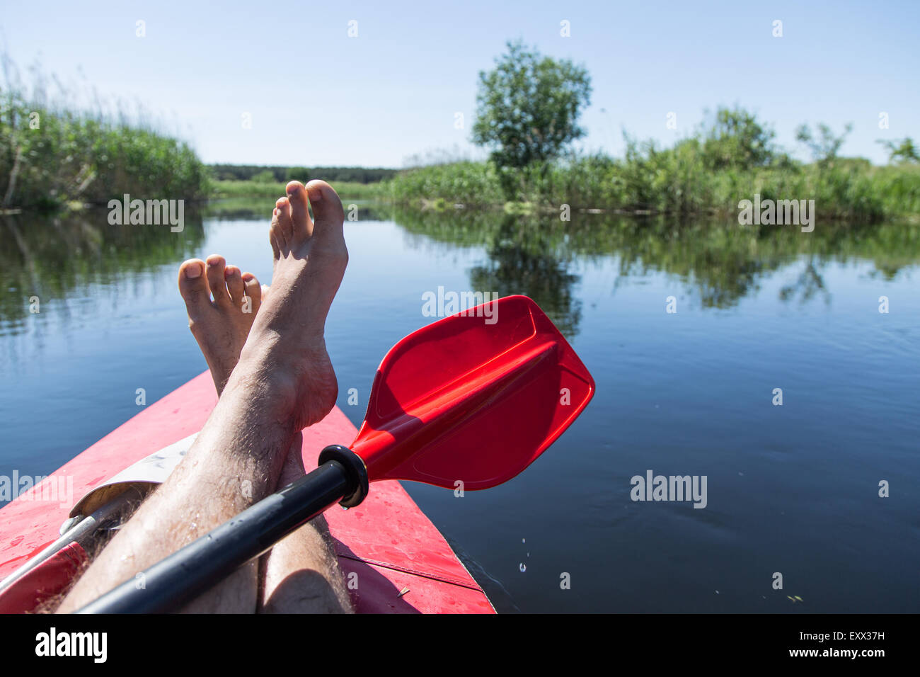 Uomo di gambe su canoe. Tempo di riposo. Foto Stock