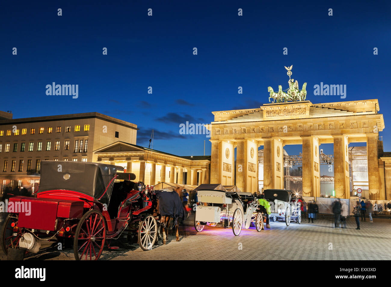 Carrelli a cavallo di fronte illuminata Porta di Brandeburgo Foto Stock