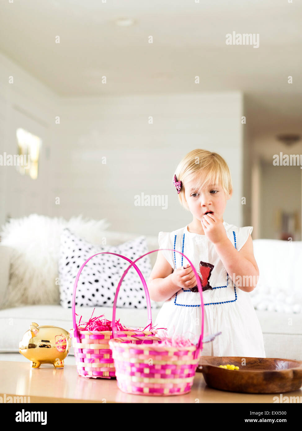 La ragazza (2-3) mangiando caramelle in salotto Foto Stock