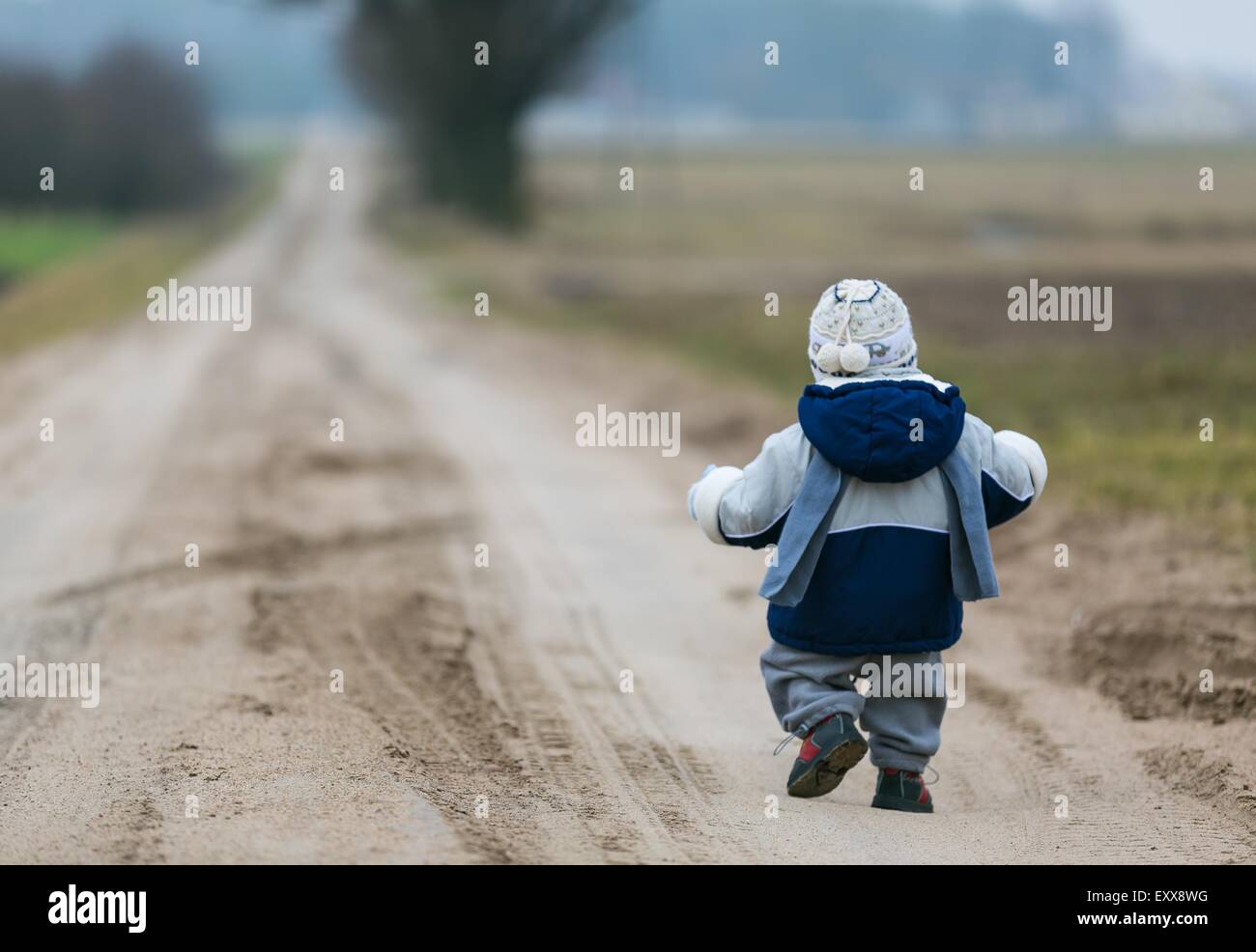 Bambini Bimbi a piedi da rurale strada sabbiosa nei primi giorni di primavera Foto Stock