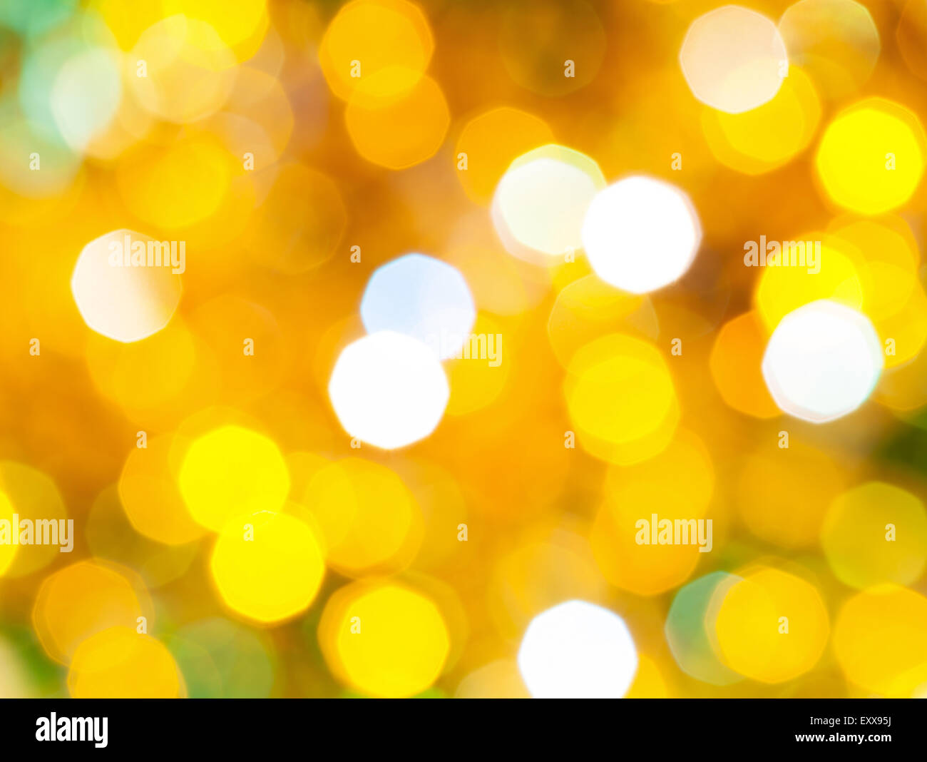Abstract sfondo sfocato - luminoso giallo e verde scintillanti luci di Natale di le ghirlande elettriche su albero di Natale Foto Stock