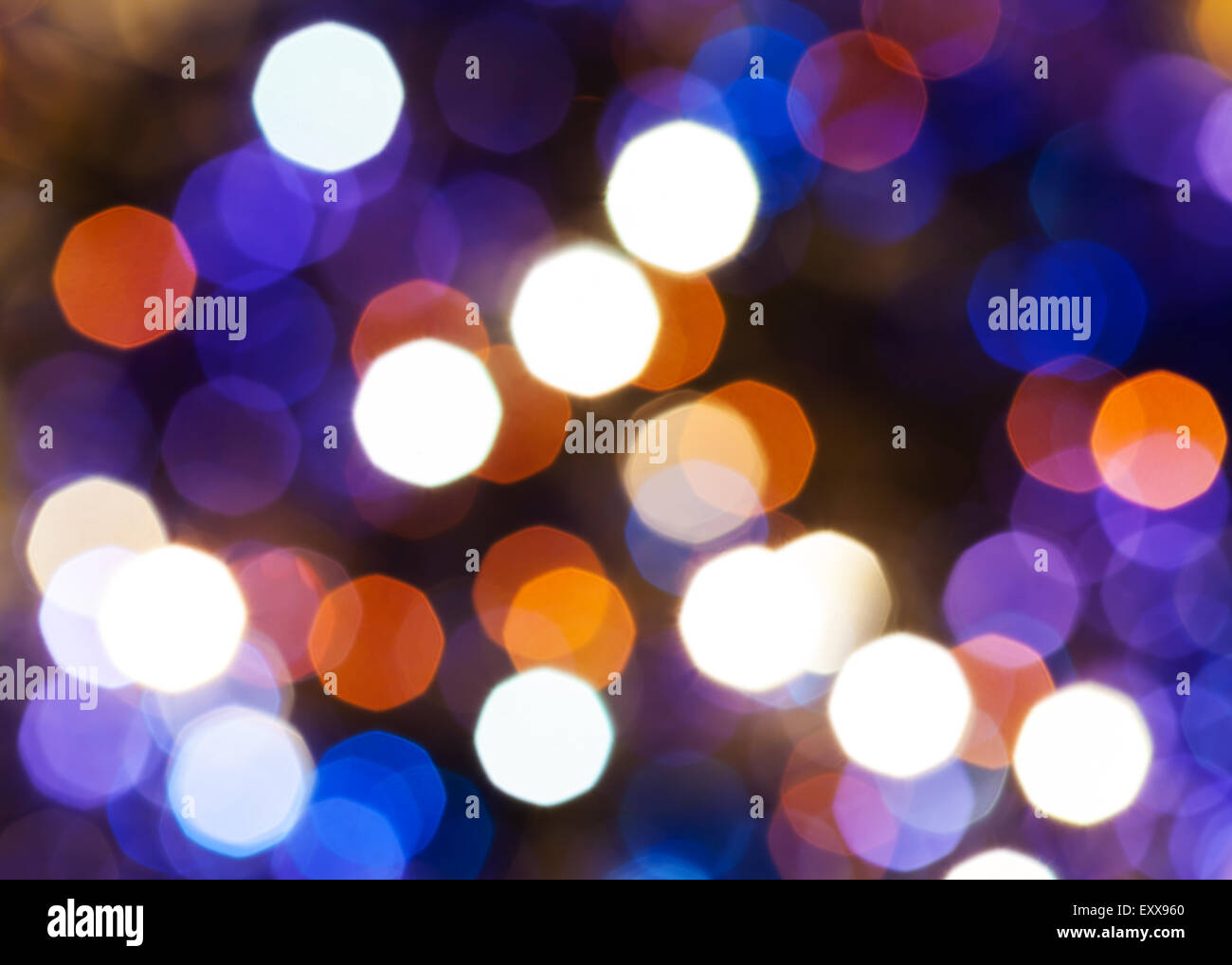 Abstract sfondo sfocato - blu, rosso e viola scintillanti luci di Natale di le ghirlande elettriche su albero di Natale Foto Stock
