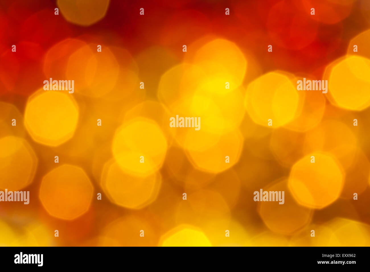Abstract sfondo sfocato - big del giallo e del rosso di sfarfallio delle luci di Natale di ghirlande su albero di Natale Foto Stock