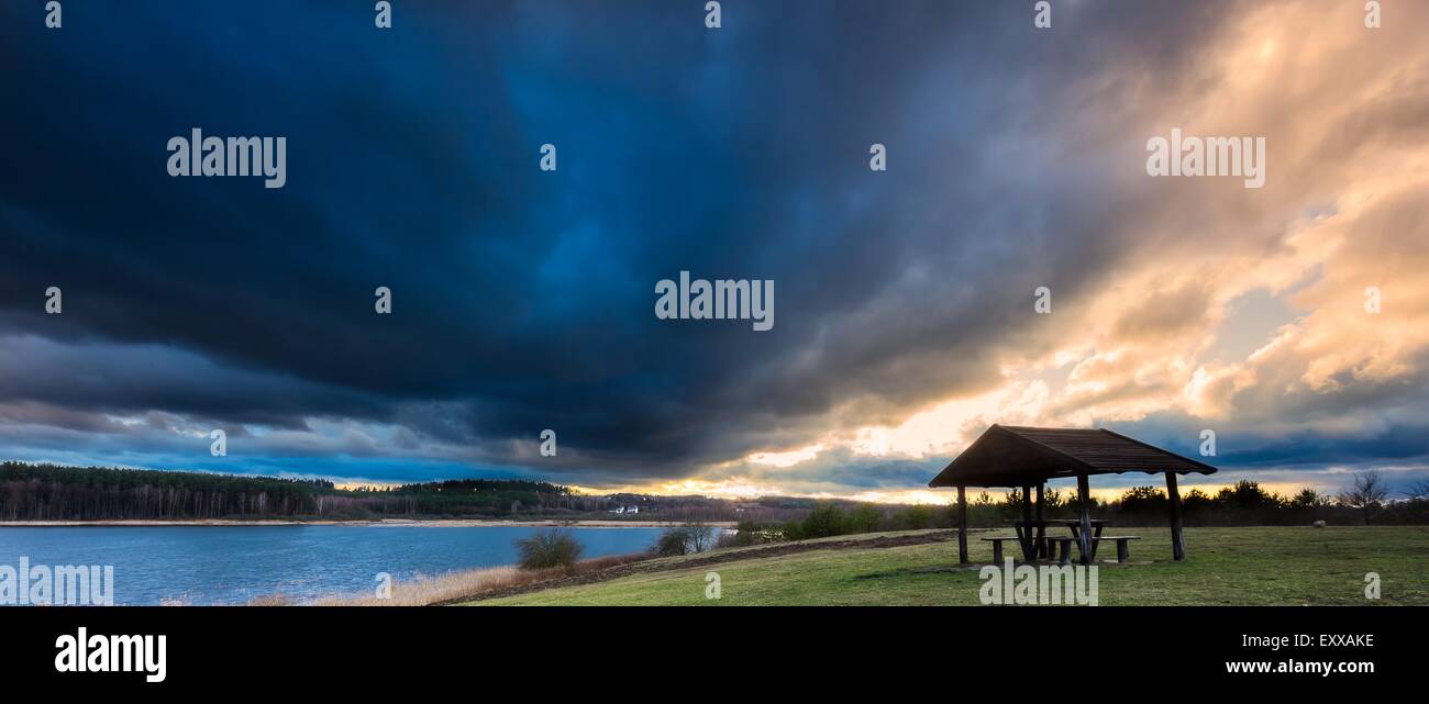 Splendido paesaggio della capanna in legno sotto il cielo drammatico. Paesaggio con il brutto tempo e colori vibranti. Foto Stock