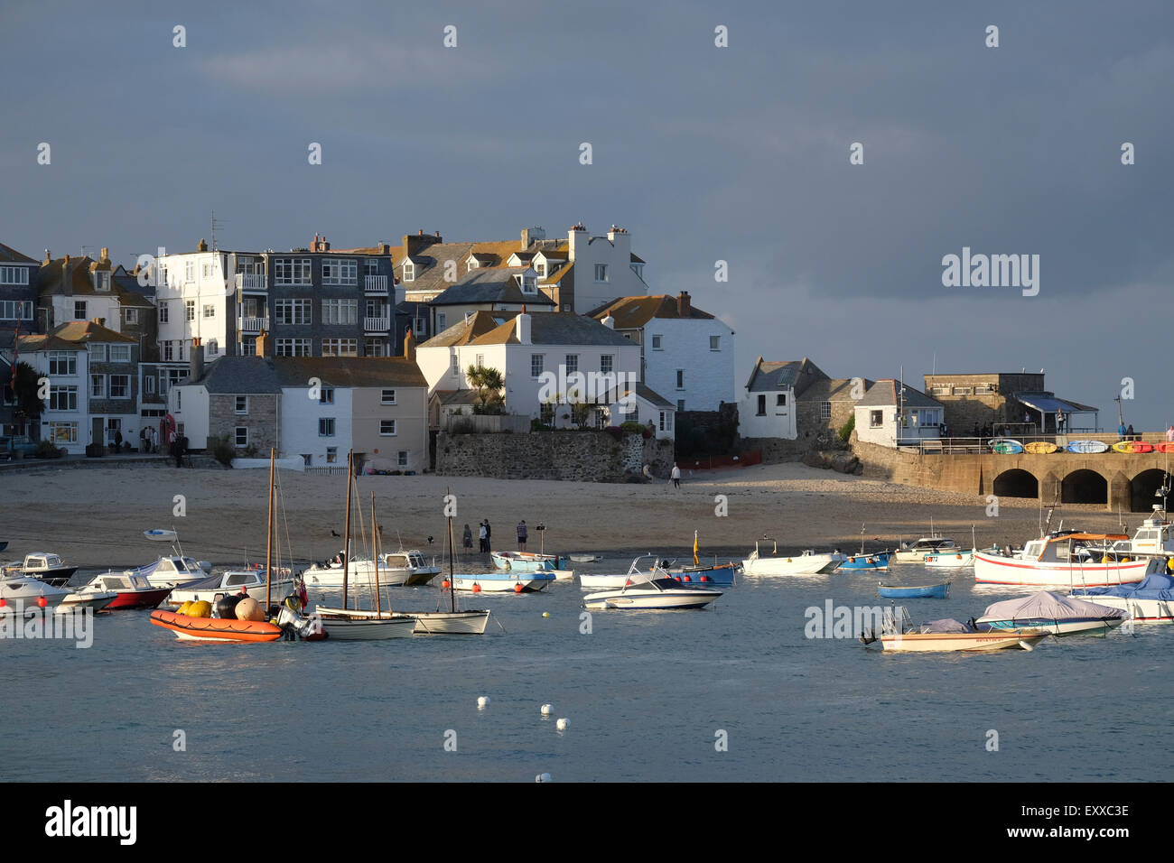 St Ives, Cornwall, Regno Unito: la sera tardi sun cattura le sommità di edifici lungo St Ives harbour front. Foto Stock