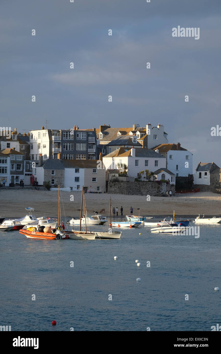 St Ives, Cornwall, Regno Unito: la sera tardi sun cattura le sommità di edifici lungo St Ives harbour front. Foto Stock