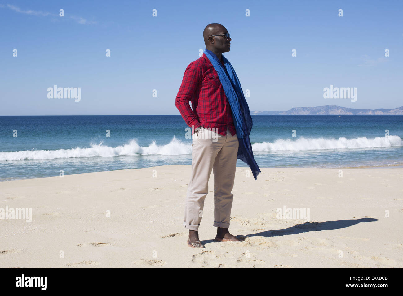 Uomo in piedi da sola sulla spiaggia Foto Stock