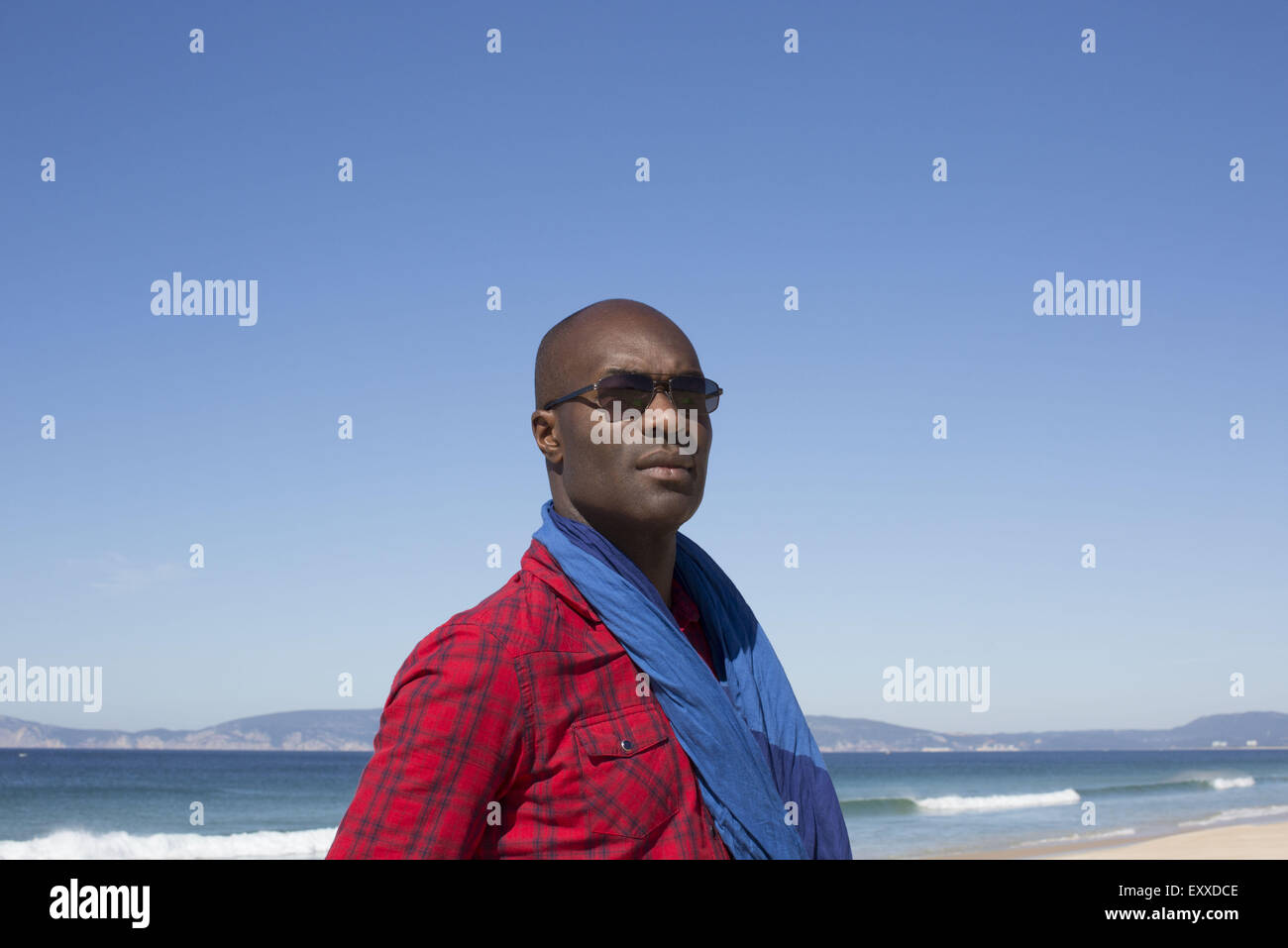 Uomo in spiaggia, guardando lontano nel pensiero, ritratto Foto Stock