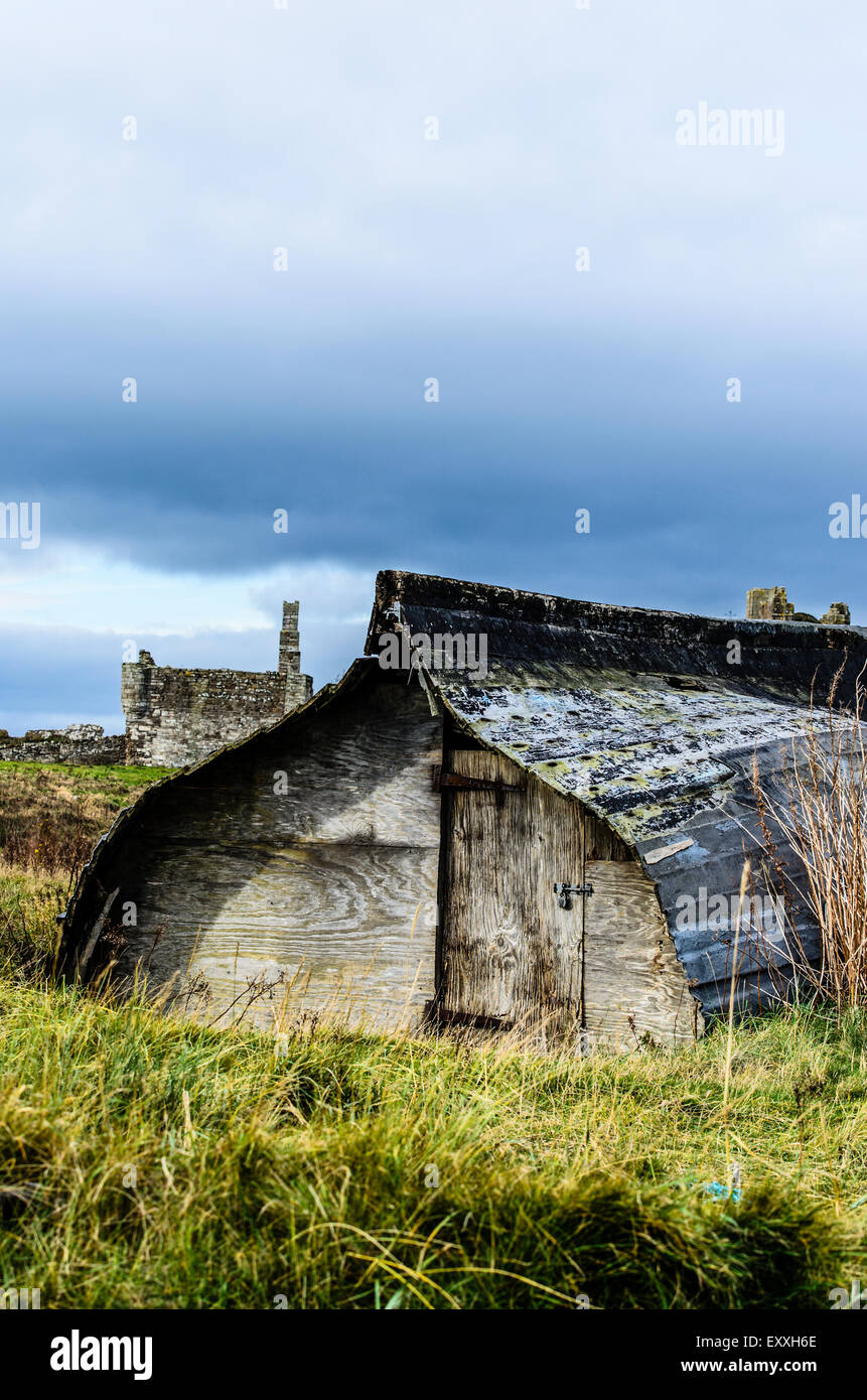 Vecchia barca capovolti e utilizzata come storage su Lindisfarne Agrifoglio Isola Northumberland. Foto Stock