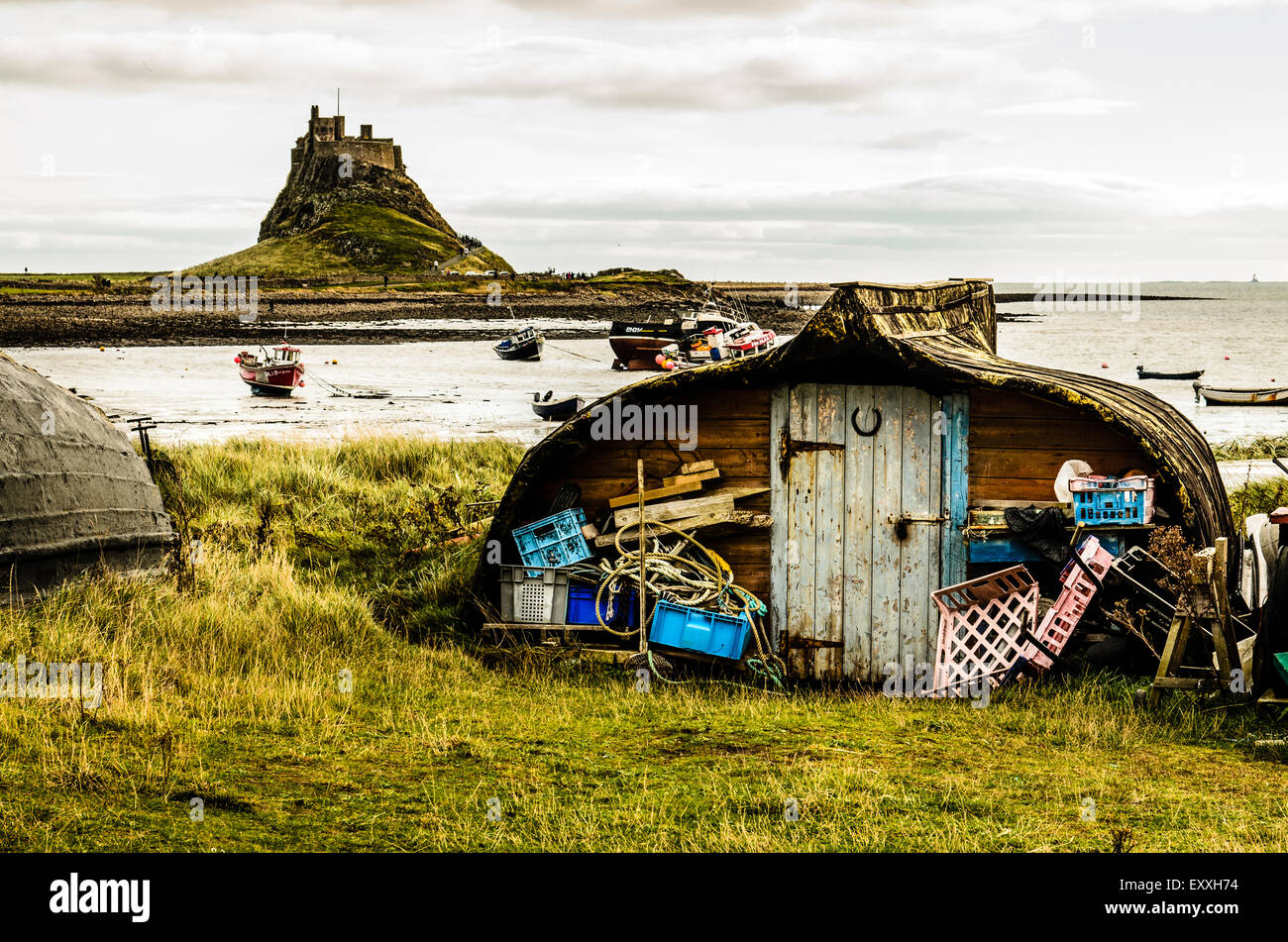 Capovolta vecchie barche usate un capannone o la memorizzazione su Lindisfarne. Foto Stock