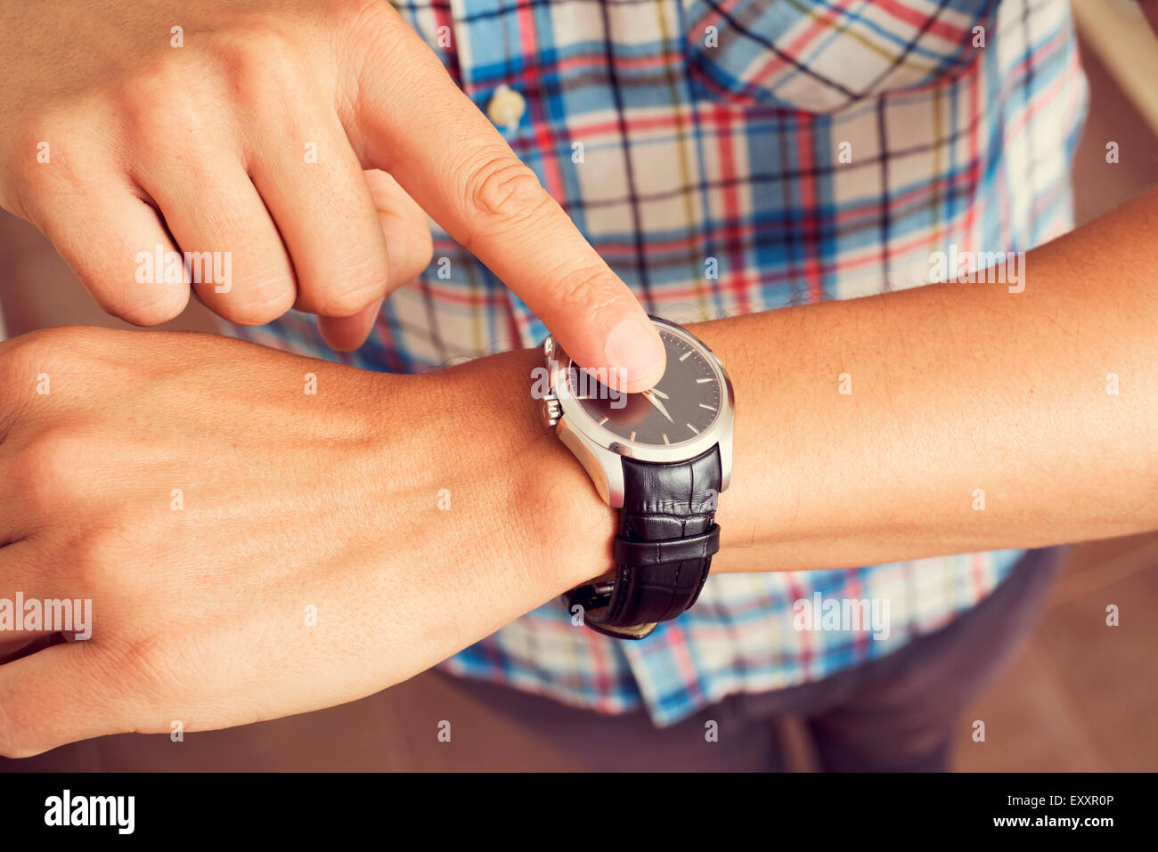 Primo piano di un giovane uomo caucasico toccando il suo dito indice sul  suo orologio da polso Foto stock - Alamy