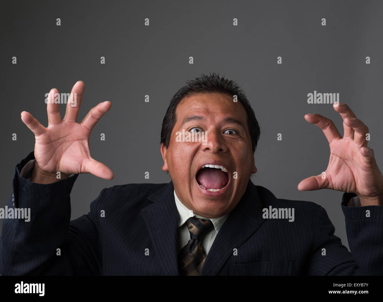 Un imprenditore ispanica guardando spaventato e timoroso. Foto Stock