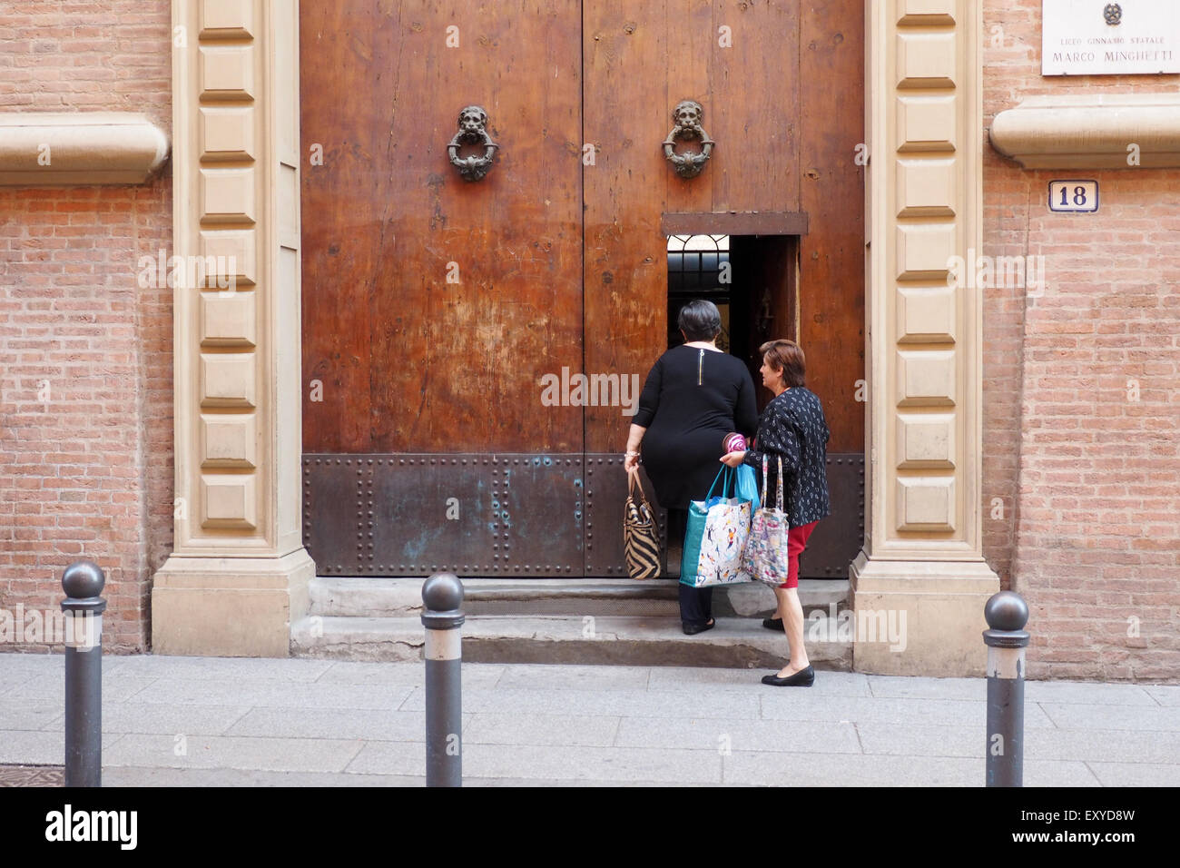 Due donne a entrare in una porta di Marco Minghetti, High School, Bologna. Foto Stock