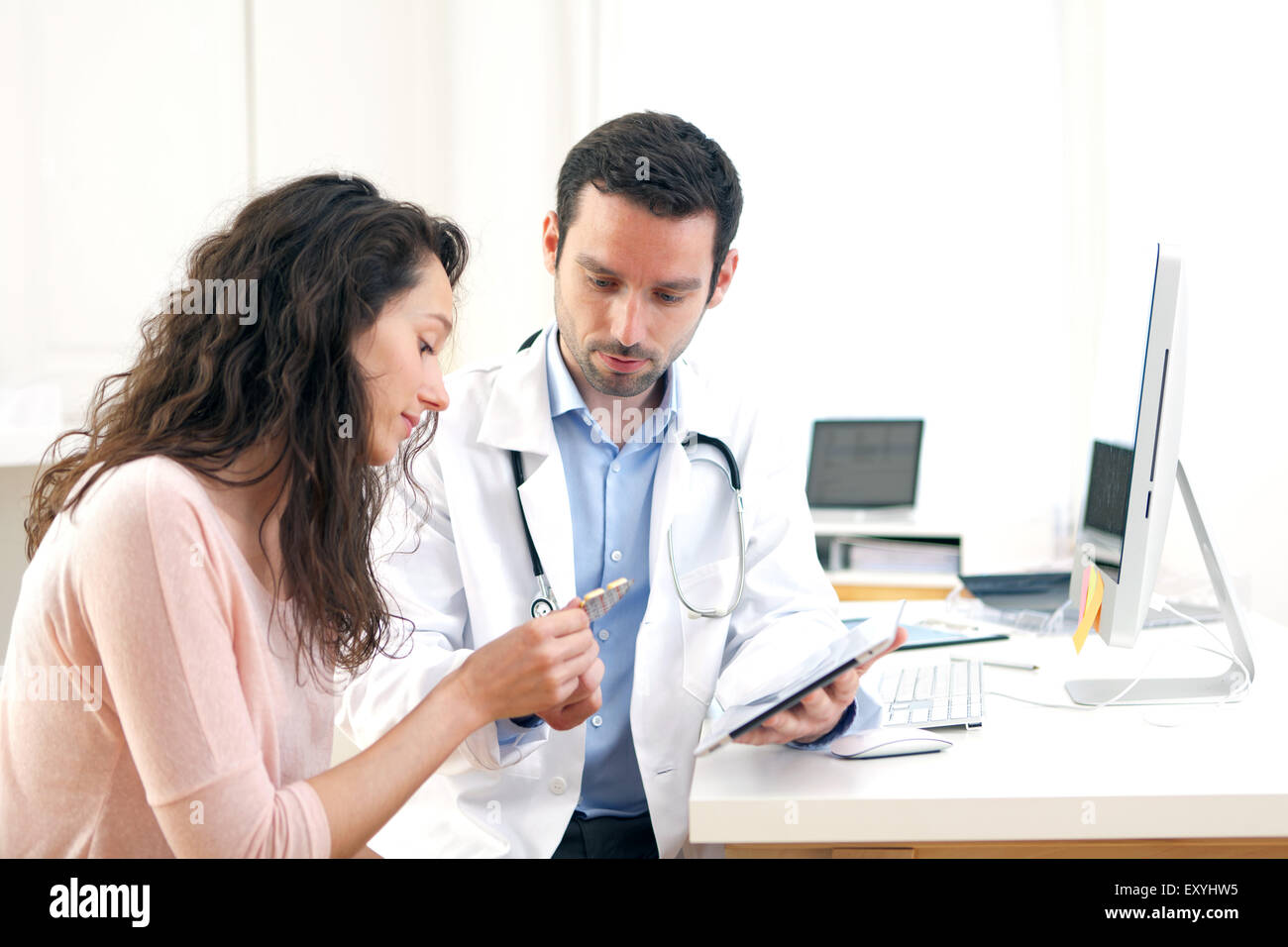 Vista di un medico utilizzando tablet per informare il paziente Foto Stock