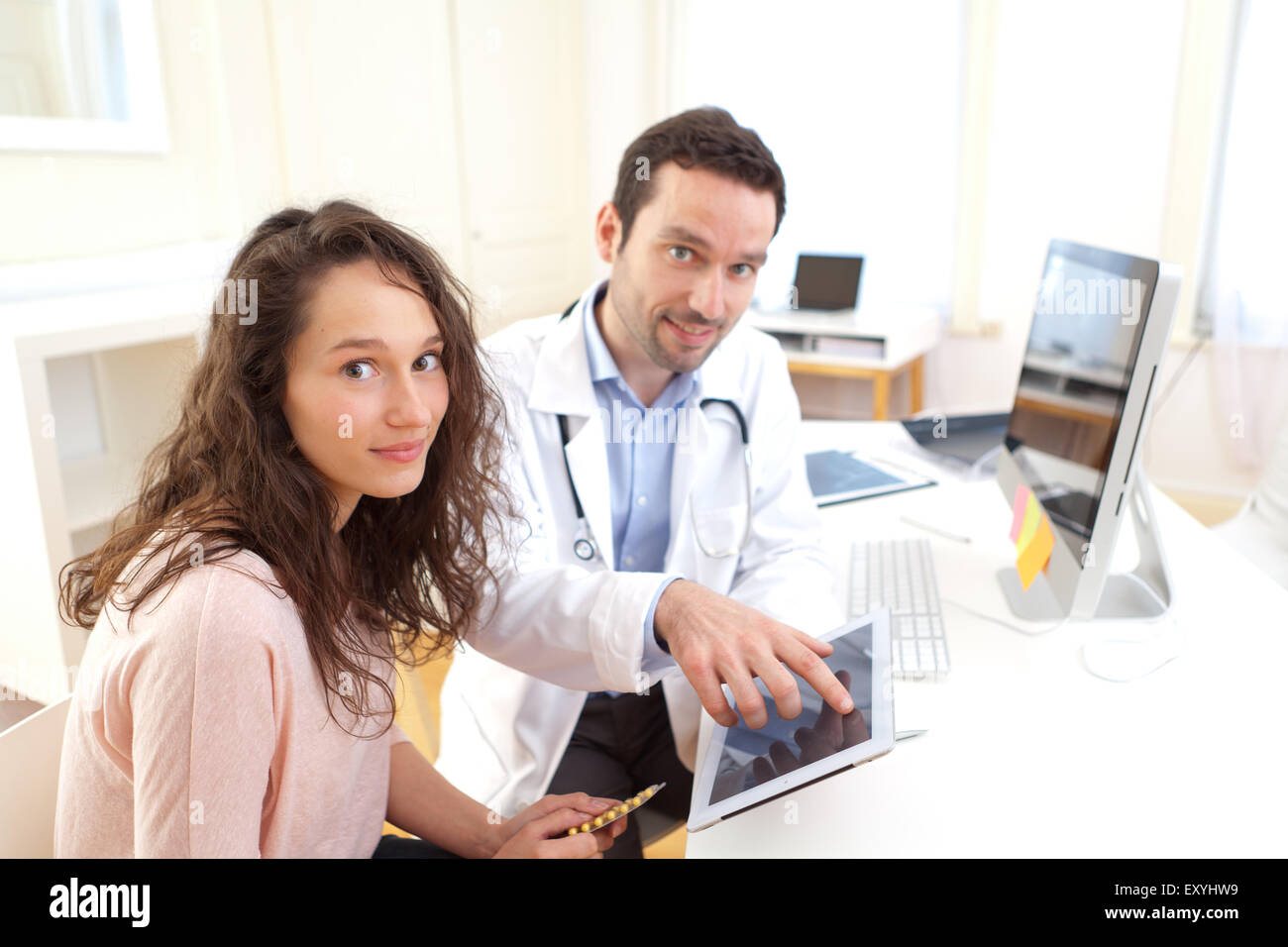 Vista di un medico utilizzando tablet per informare il paziente Foto Stock