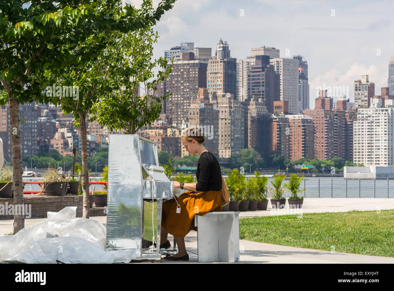 New York City, NY, USA, Jewish Girl Playing piano on Hunter's Point, South Park, Long Island City, East River, vista skyline di Manhattan, Parco giochi urbano, edifici cittadini Foto Stock