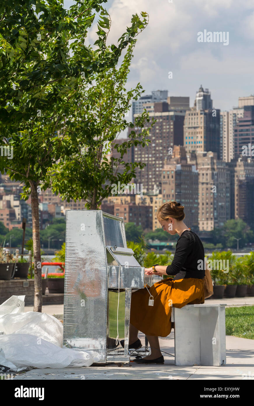 New York City, NY, STATI UNITI D'AMERICA, ragazza ebrea suonando piano sulla banca del fiume del cacciatore del punto, South Park, "Long Island City', (East River), vista dello skyline di Manhattan Foto Stock