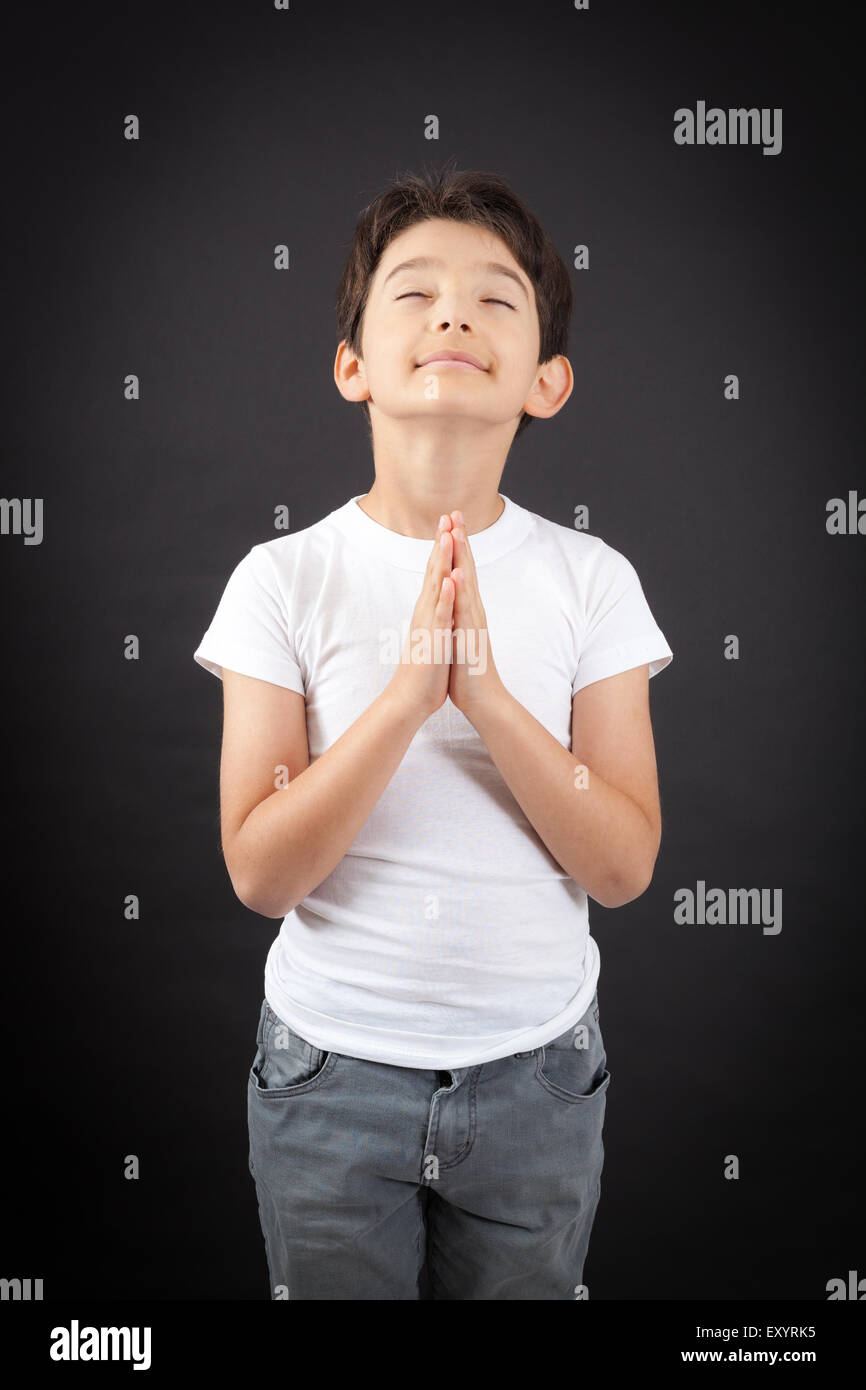 Bel ragazzo facendo espressioni diverse in diversi set di vestiti: la preghiera Foto Stock