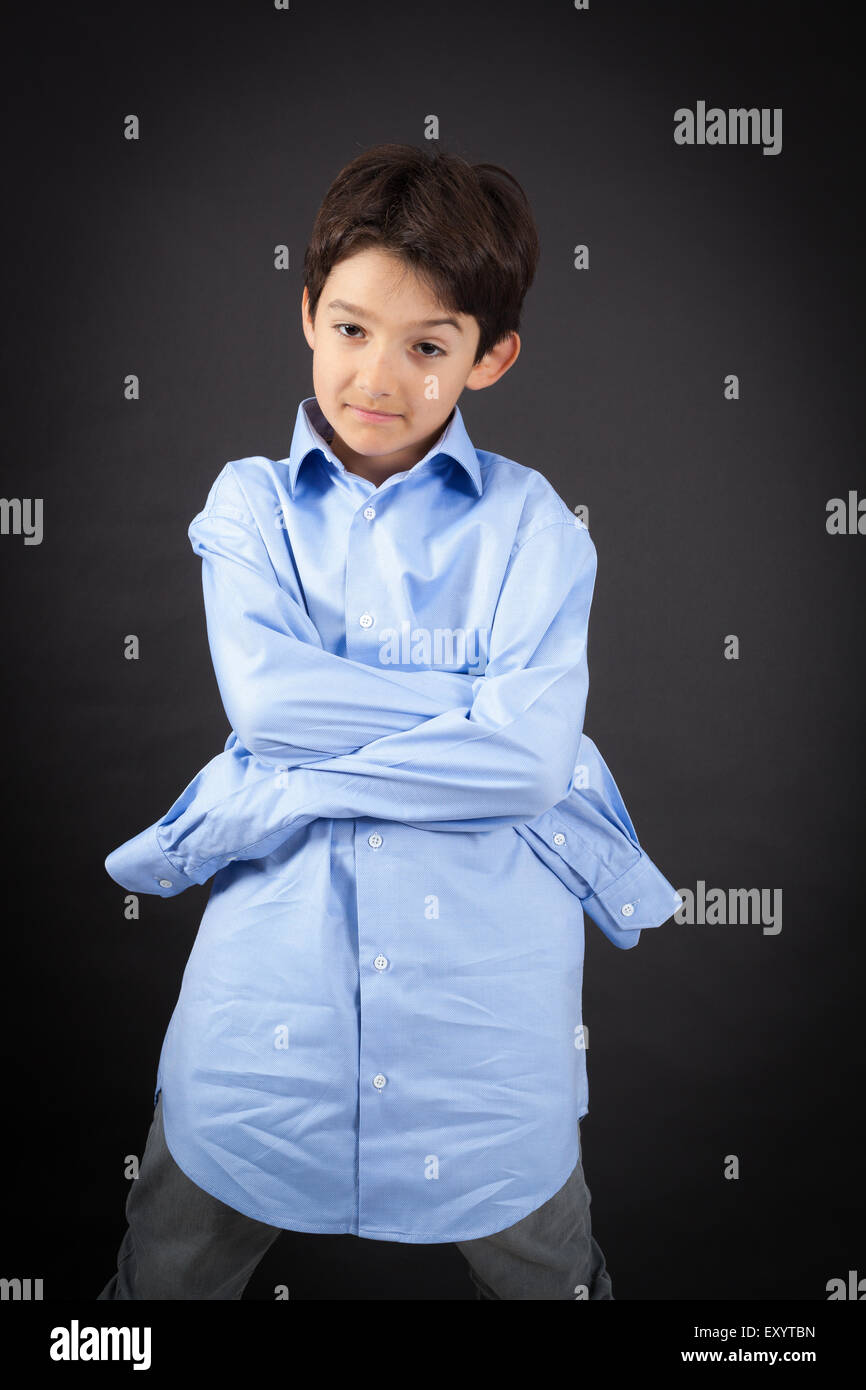 Bel ragazzo facendo espressioni diverse in diversi set di vestiti: braccia incrociate Foto Stock