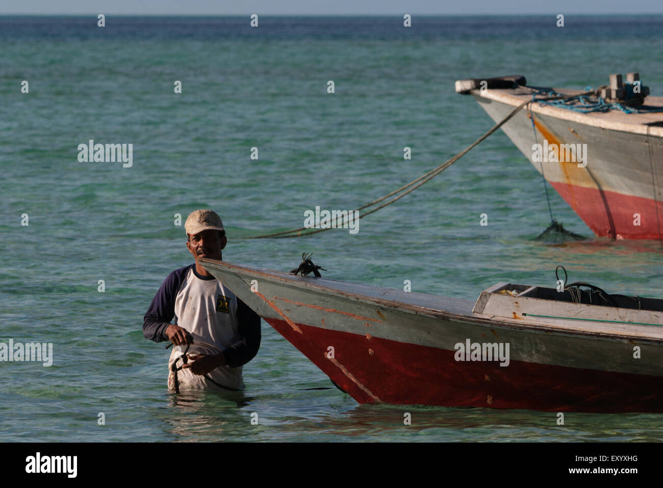 Ritratto di un pescatore in piedi sulle acque costiere di Derawan Island, una parte della Berau Marine Protected Area a Berau, Kalimantan Est, Indonesia. Foto Stock