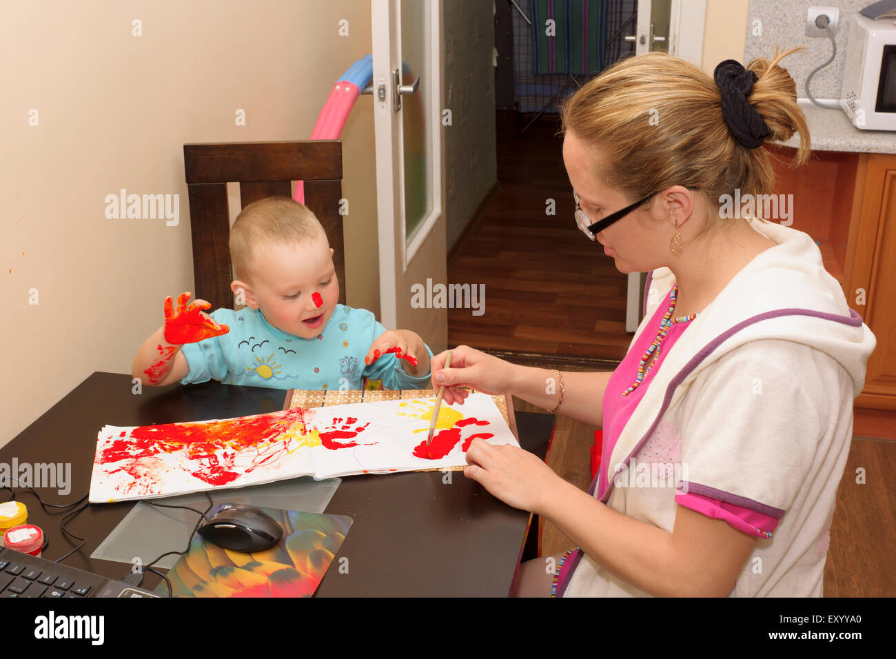 La madre e il bambino disegna le vernici luminose Foto Stock