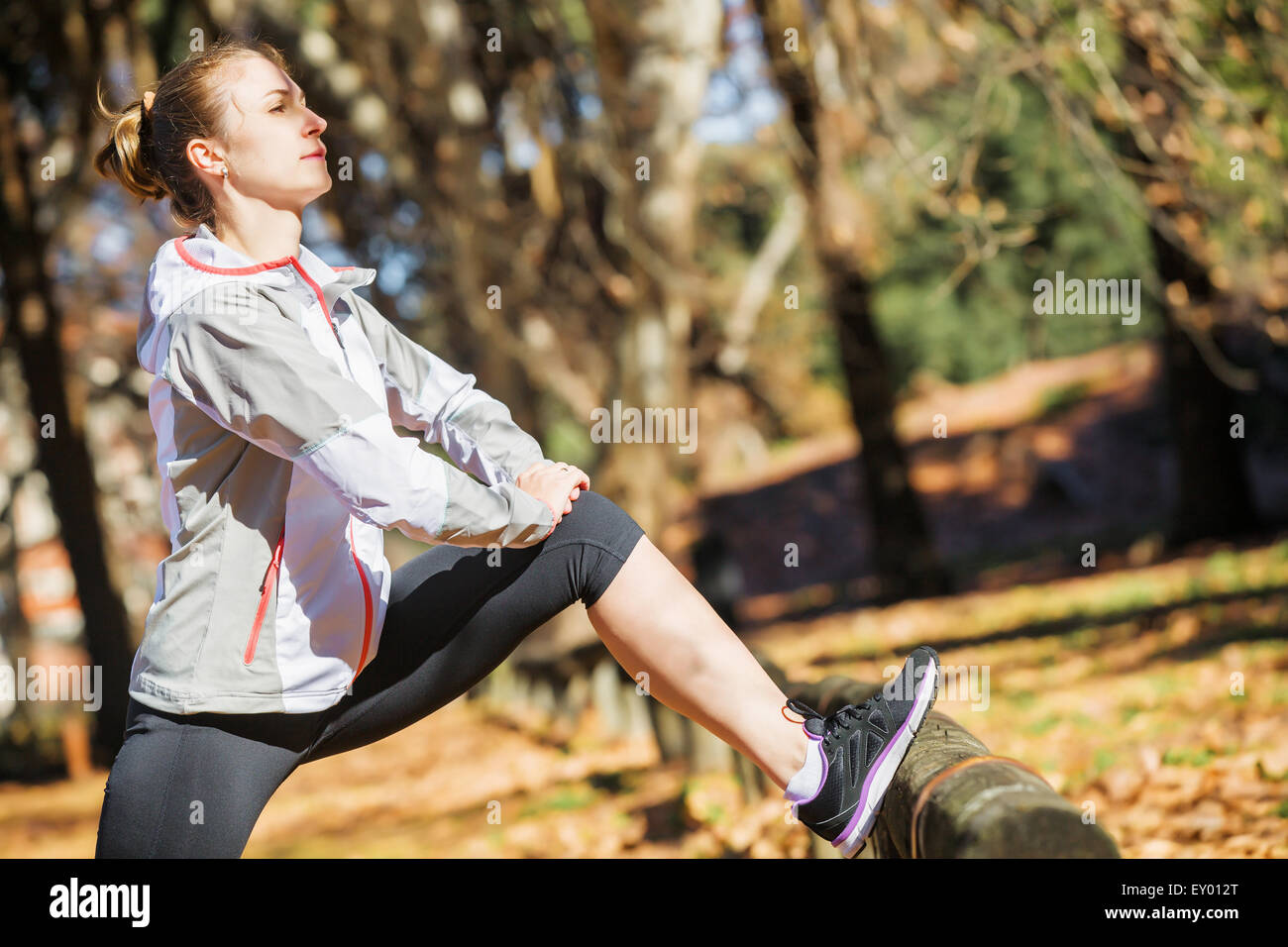 Montare giovane ragazza distesa su un banco di lavoro prima di esercitare in autunno park Foto Stock