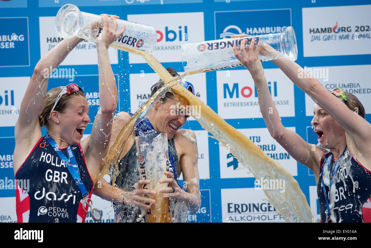 Amburgo, Germania. 18 Luglio, 2015. Gwen Jorgensen (C) degli Stati Uniti d'America festeggia sul podio dopo aver vinto il Mondiale ITU Triathlon evento di Amburgo ad Amburgo, Germania, 18 luglio 2015. Jorgensen ha vinto davanti al secondo posto Vicky Holland (L) e il terzo posto non lo Stanford (R), entrambi della Gran Bretagna. Foto: DANIEL REINHARDT/dpa/Alamy Live News Foto Stock