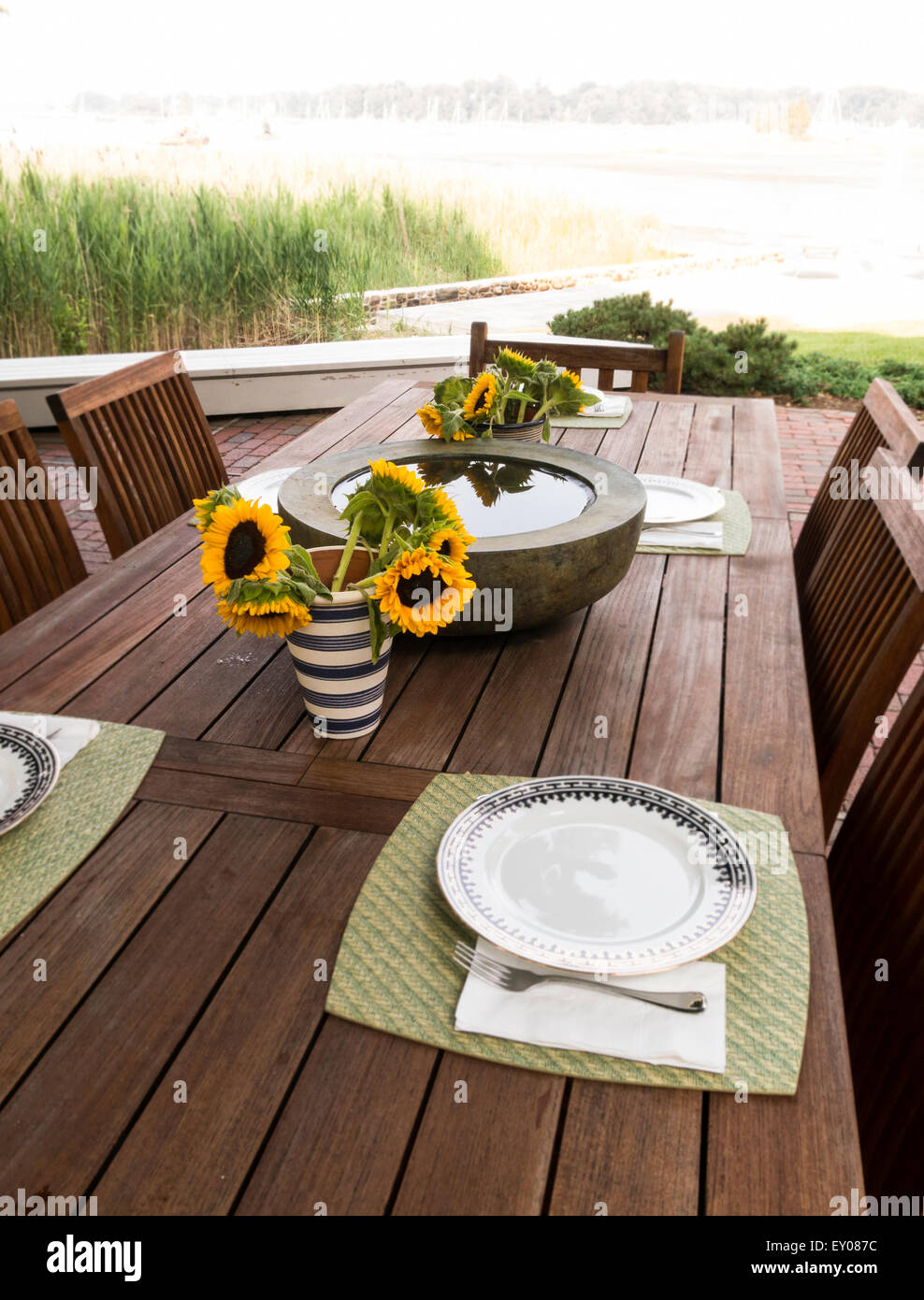 Decorativo cisterna di acqua e di girasoli sul patio esterno tavolo, STATI UNITI D'AMERICA Foto Stock
