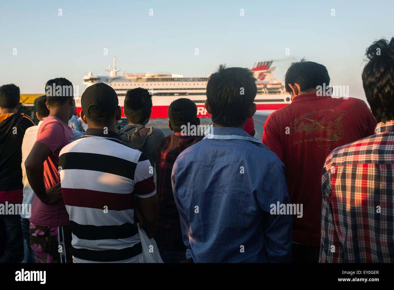 I migranti e i rifugiati dalla Siria, Pakistan e Bangldesh attendere al porto per arrivare su una nave che li porterà dall'isola greca di Kos a Atene, domenica 12 luglio, 2015. Foto: Santi Palacios/dpa Foto Stock