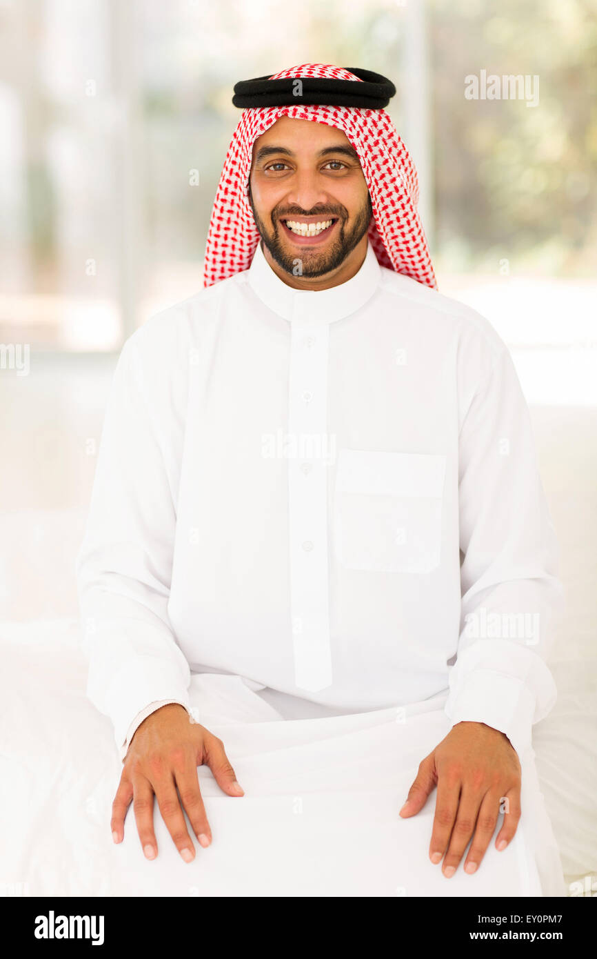 Allegro giovani Arabian uomo seduto a casa Foto Stock