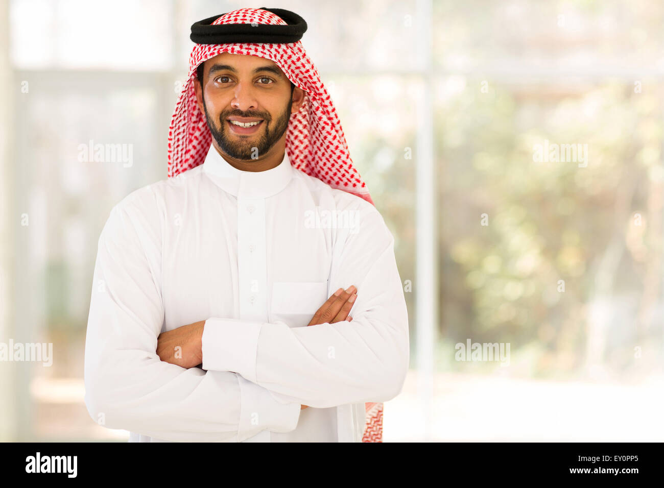 Sorridente uomo arabo con le braccia incrociate Foto Stock