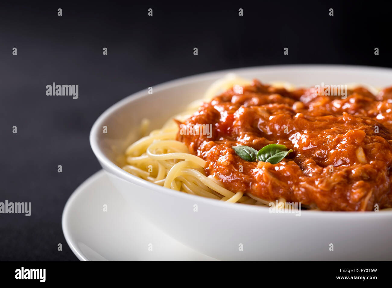 Spaghetti con sugo di tonno su sfondo nero con spazio di copia Foto Stock