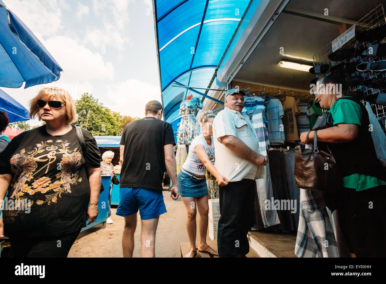 GOMEL, Bielorussia - Giugno 10, 2014: un uomo non identificato è di acquistare una maglietta a un mercato locale Foto Stock