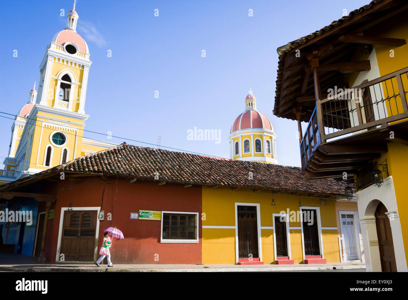 Donna locale con il suo bambino a camminare per le strade di Granada città vecchia, Nicaragua Foto Stock