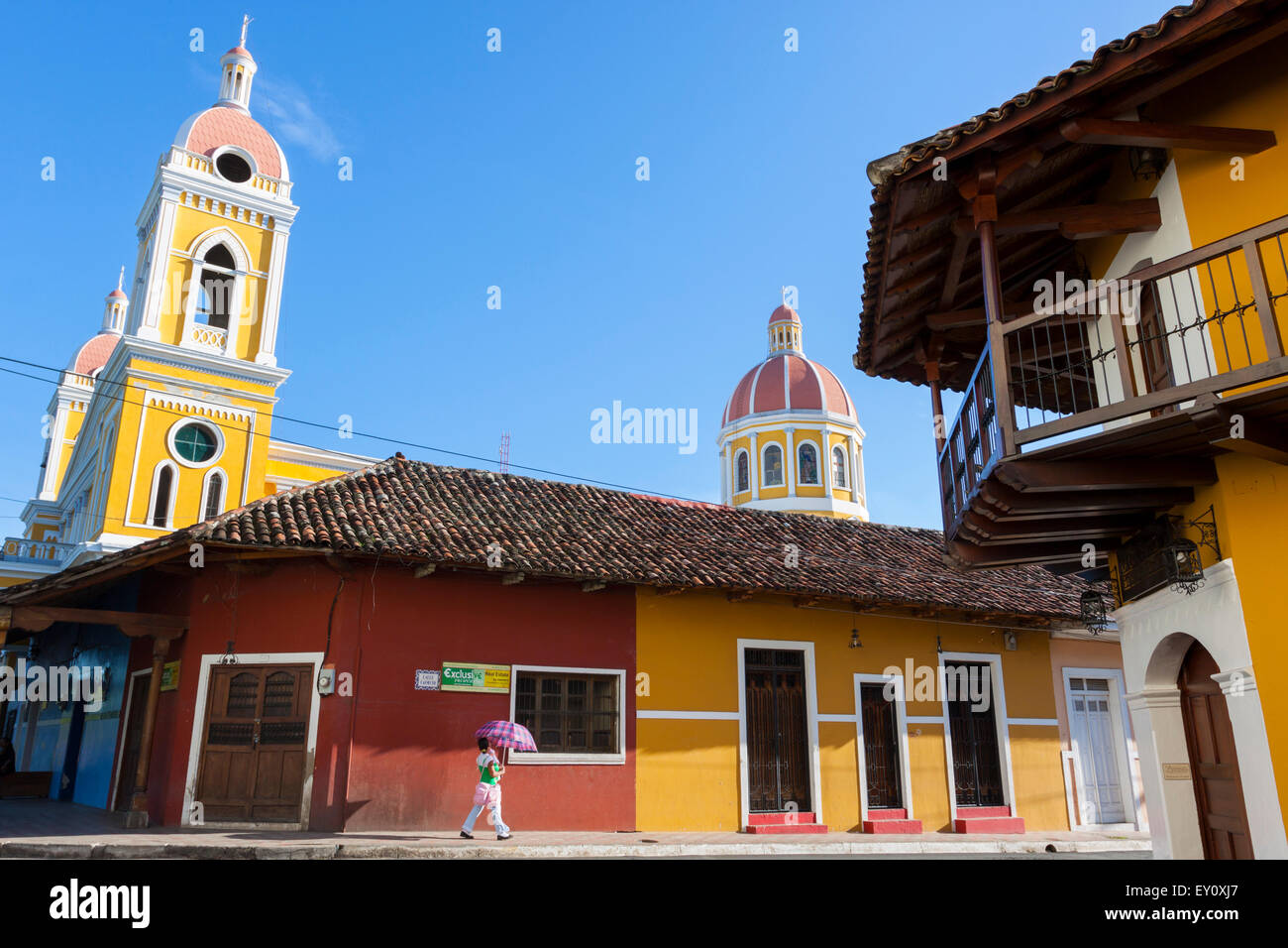 Donna locale con il suo bambino a camminare per le strade di Granada città vecchia, Nicaragua Foto Stock
