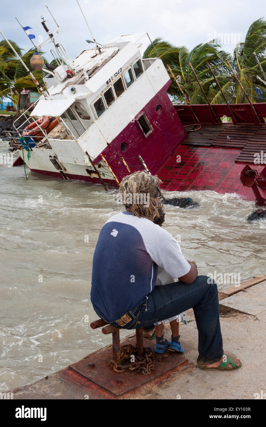 Padre e figlio guardando i danni causati dal passaggio dell uragano Ida in Big Corn Island dock, Nicaragua Foto Stock